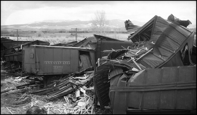 Extra 5121 West rear-ended the main line local, Extra 1816 West, at Drummon, MT. This accident resulted indirectly from the events surrounding the derailment of wrecker 47 east of Missoula (see RVN09581-09595). Missoula engineer Charles F. Reinke and his fireman had been on a layover in Helena when they were called to take Helena wrecker no. 37 to Missoula to help re-rail wrecker 47. In the meantime, officials decided to use a small wrecker from the Missoula car shop to assist wrecker 27 for that job, so Reinke and his fireman were stopped at Garrison and sent back to Helena. Then, after returning to Helena, they were called short of their legal rest period to handle Extra 5121 West. According to railroad officials, as Reinke approached Drummond he and his fireman had probably fallen asleep and missed block signals protecting the rear of Extra 1816 West. Extra 1816 West's conductor looked out the back of his caboose just in time to see the high speed approach of Extra 5121 West, so he ran into the nearby field. His brakemen were already on the ground giving signals for switching moves they were making at Drummond. The big Z-7 4-6-6-4 type locomotive plowed into the local's wooden caboose at high speed. There were only minor injuries to the crews involved. Conductor Emil Berglin was in charge of Extra 5121 West. Engineer Elmer Walkup and Conductor Malcom McCauley were handling the local.