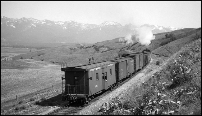 NP Extra 1818 East has just left Polson and heads toward Pablo, Montana, on May 10, 1946. Engineer John A. Mooney is in charge of the Class W-3 Mikado locomotive. His fireman's date is February 1, 1903, and he was promoted to engineer on January 4, 1907. Conductor Marion P. Russell is in charge of the train. He has a brakeman's date of October 1, 1907, and he was promoted to conductor only two weeks later, on October 16, 1907. This local is making its way to Dixon, where it will enter the Rocky Mountain Division's Sixth Subdivision, the main line extending between DeSmet and Paradise and also known as the 