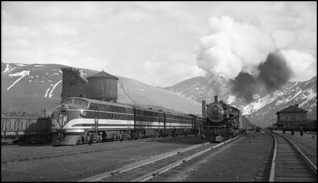 NP Train No. 1 with NP 2610, Class A at Missoula Depot while NP Train 603, powered by Electro Motive 103, an experimental diesel electric locomotive sits in yard.  Test train 603 encountered delays due to Quartz tunnel caving in.  Required steam helpers to get through reroute.