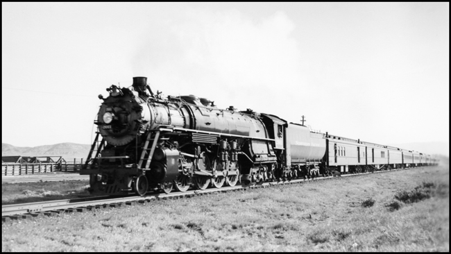NP train No. 1, with NP 2661, Class A-3 with Engr H Jondrow, just east of Livingston, passing stockyards on its way eastward.