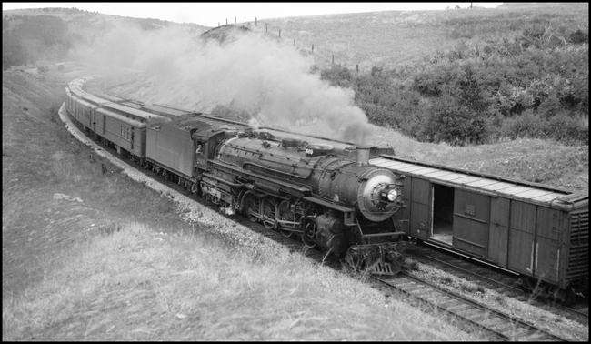 NP Train No. 4 with NP 2609, Class A locomotive, passing freight train.