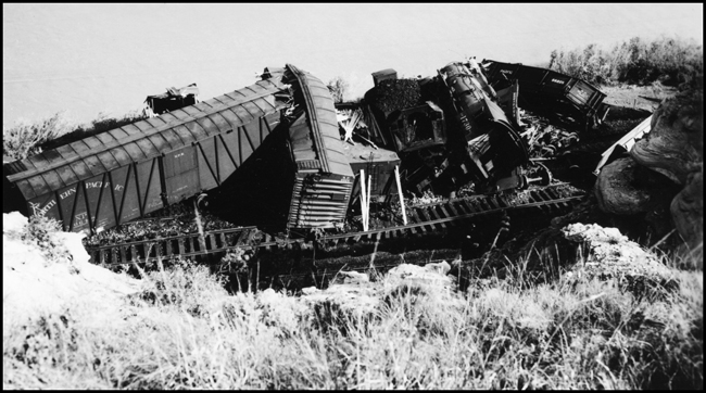 View of accident involving NP train X1730E which collided with a work train near Lockwood, east of Billings.  There were no fatalities but several were injured.  NP 1730, Class W-3 was extensively damaged. Freight cars rail and locomotive scattered through this view of accident.