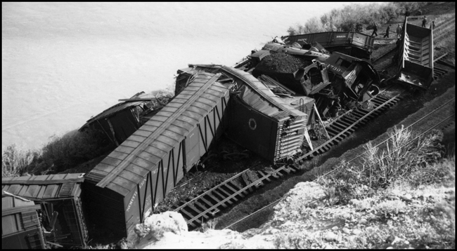 View from high above the accident involving NP train X1730E which collided with a work train near Lockwood, east of Billings.  There were no fatalities but several were injured.  NP 1730, Class W-3 was extensively damaged. Freight cars rail and locomotive scattered through this view of accident.