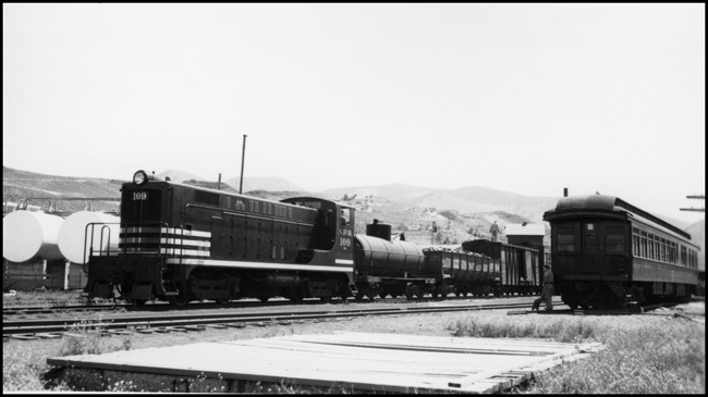 NP train No. 233 with Alco switcher NP 109 switching in Gardiner,  MT with passenger coach sitting on siding in yard.