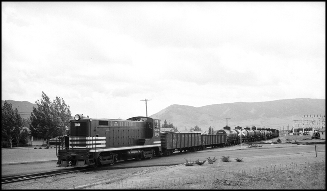 A diesel powered branchline freight nears the end of its northbound run.  The head brakeman is riding up front, ready to get off and throw a few switches at Livingston MT.