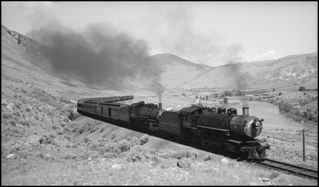They may be too old for prime mainline assignments, but a W and a Q-3 can still handle a respectably large train, even if the action is on a branchline.  Two steamers are hauling a trainload of vacationers to Yellowstone.