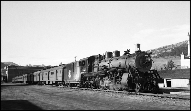 A passenger extra of an unusual nature is awaiting departure at Helena.  What makes this train unusual is that many of the passengers, riding in the unusual cars at the head end of the train, are horses.  They are race horses headed to Calgary, Alberta.