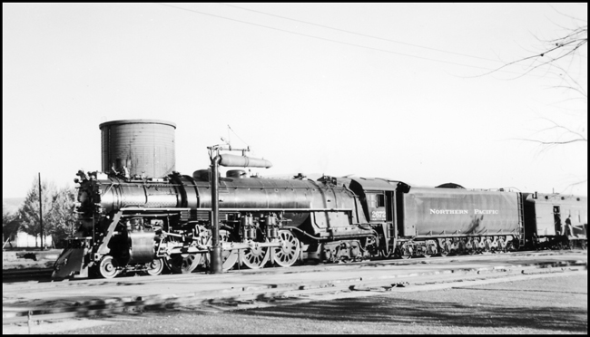 NP 2672, Class A-4 locomotive has just coupled on to a passenger run and is getting ready to leave Livingston for the west. Baggage and Express car being loaded behind tender.