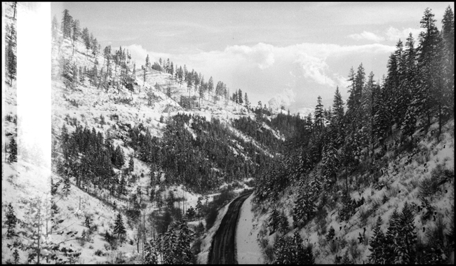 The tracks are far above the highway, and a close study will spot the North Coast Limited west, doubleheaded as usual, with a W-3 and an A.