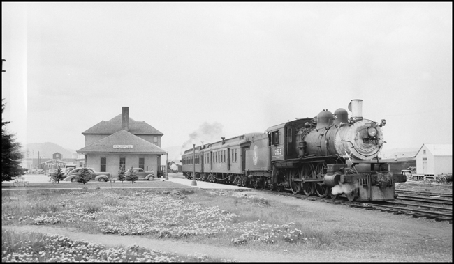 GN Train No. 244 pulled by GN 1053, 4-6-0 locomotive on passenger train at Kalispell, MT