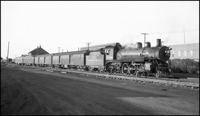 NP Train No. 11 with NP 2189, Class Q-4 stopped at Depot in International Falls and trainman is servicing locomotive.