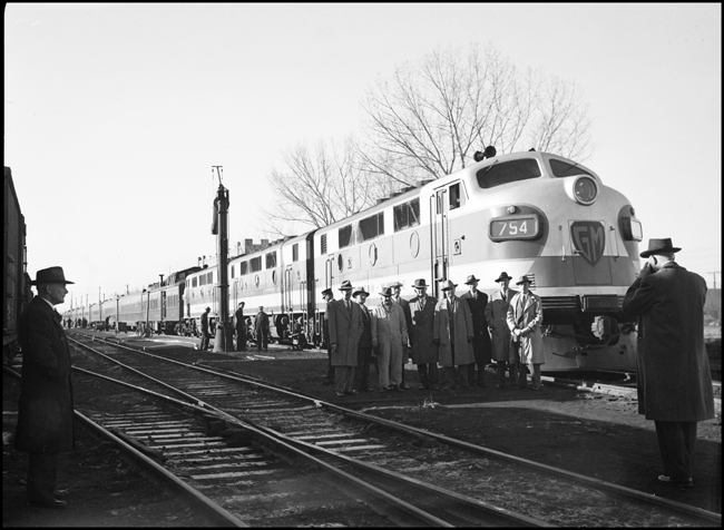 Officials pose in front of NP No. 3 /2 w/ GM 754 at Glendive ,MT, while passenger equipment is being serviced.
