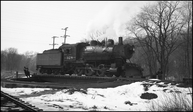 The class S-10 328 was part of a group of locomotives built for another railroad, and purchased by NP when that railroad defaulted on the order.  The 328 was saved after dieselization, and for many years pulled excursion trains in northern Minnesota.  In 2006 it may be found in the Jackson Street Roundhouse in Minneapolis awaiting rebuilding.  It has just pulled a mixed train to the end of the Taylors Falls branch line, and is being turned on the 