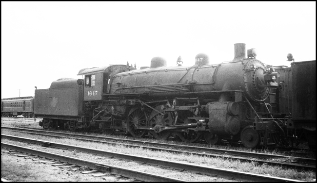 Chicago and Northwestern 4-6-2 1647 in Council Bluffs yard, coupled to tender.
