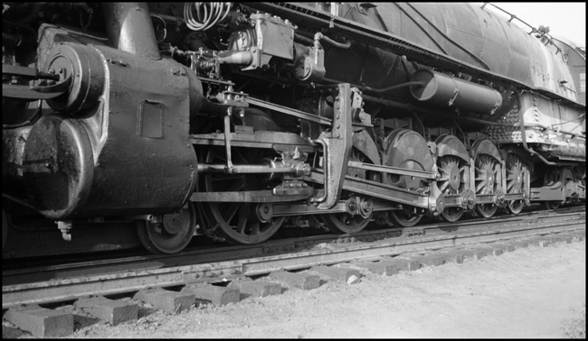Closeup of left side running gear and cylinder of Union Pacific 4-12-2, Council Bluffs, IA, yard.