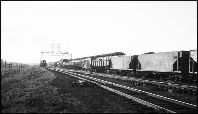 Going away shot of UP Extra 2314 West, eng. 2314, and gondolas, passing ice house, Council Bluffs, IA.