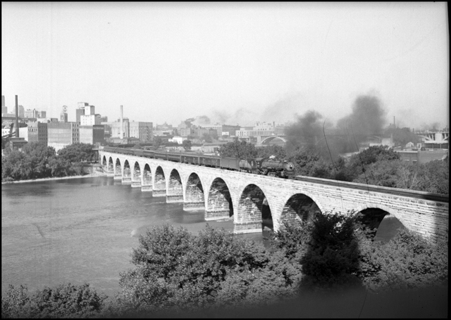 Eastbound GN passenger train on Stone Arch Bridge, Minneapolis, with 4-8-2 engine 2507.