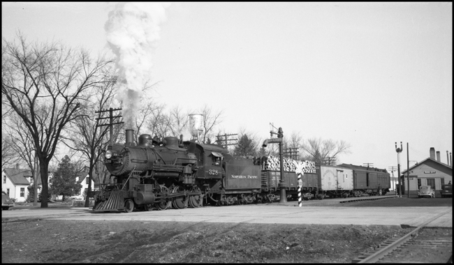 NP Train No. 735, with NP 328, Class stopped at Rush City Depot.  Cndr-Robt Wilcox, Brkm-Jack Murray, Walter Ebel.