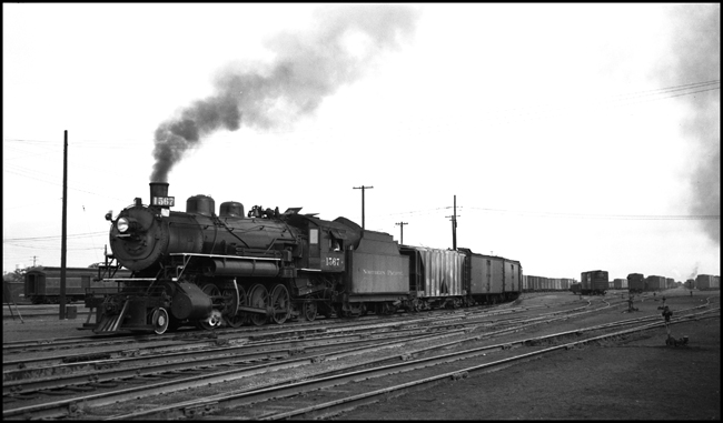 NP 1567, a 2-8-2 Mikado Class W, pulls an extra west bound freight train through Pasco yard.