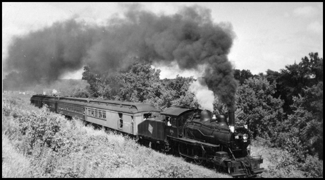 Milwaukee Road 98 is heading an extra passenger train near Chaska, Minnesota.