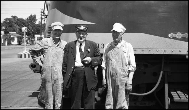 NP Conductor Norton and two unidentified train crew members standing next to NP 6513, an EMD F-7A, at Yakima, WA.