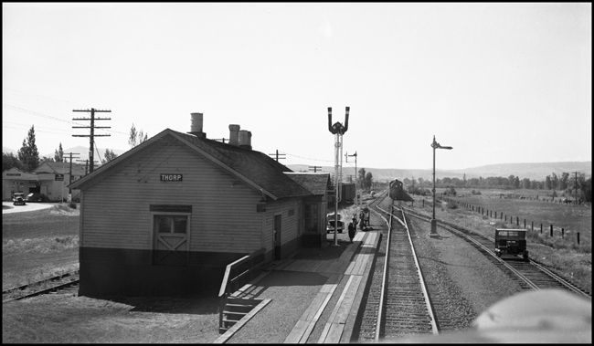 A cab view looking west to the Thorpe, WA station with extra freight train X1766E in the distance.