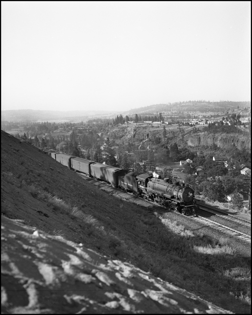 On this summer day in July 1951 near Spokane, Advanced #2, the North Coast Limited is steaming east behind Class Q-6 4-6-2 2248 carrying perishable produce from the Yakima Valley or fresh Salmon from the Pacific Northwest to Eastern markets.  After November 16, 1952, this train will be called the Mainstreeter.