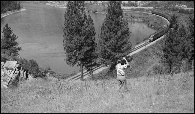 Ron Nixon photographing west bound Train No. 3, the Alaskan-Yellowstone Comet, as it runs along the Clark Fork River near Eddy, Montana.
