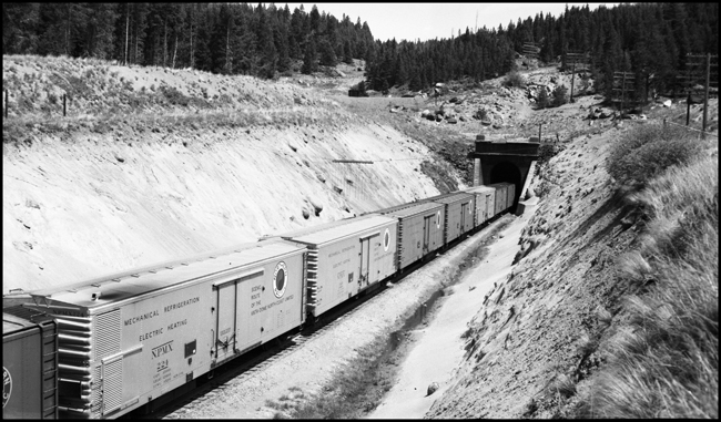 East bound freight X7014E with refrigeration cars entering the tunnel at Blossburg, MT