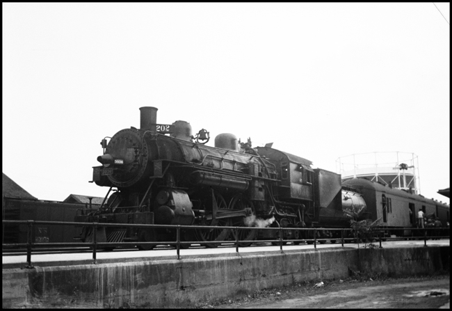 SP 3036, 4-4-2 steam locomotive, with a baggage-mail car behind where they are loading mail at Marysville, CA.