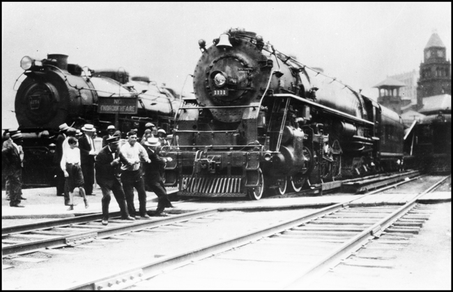 Timken 1111, NP Class A-1 locomotive built by Timken to demonstrate the advantages of roller bearing in reducing rolling friction on motive power.  After demonstrations on 14 railroads, Northern Pacific bought the Four Aces locomotive and renumbered it NP 2626.  In this advertising photo Timken was illustrating how the locomotive could be pulled by several people pulling in tug of war fashion.  This advertising photo may have been taken in Chicago.
