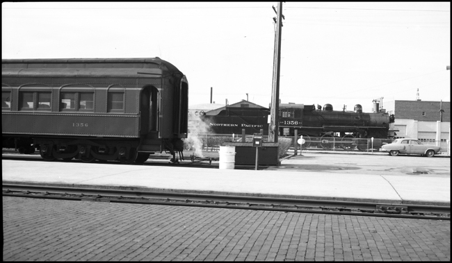 NP heavyweight coach 1356 parked on passenger car set out track at Missoula with NP 1356, Class S-4 which is on display at Missoula, visible through vestibule of coach.