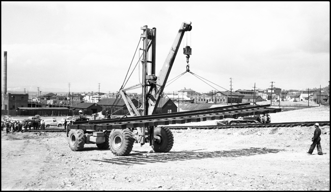 Moving panel rail for use in building railroad to move NP 25 at Butte, with huge crowd watching operation.