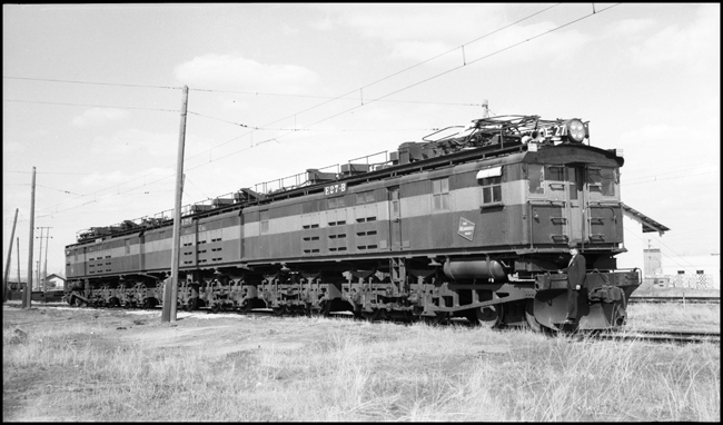 MILW E-27 electric locomotive at Three Forks, MT, with railroad person standing on front platform.