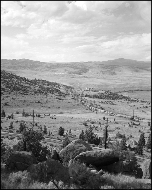 MILW E21 electric locomotive leads an extra freight train east near Cedric, MT.