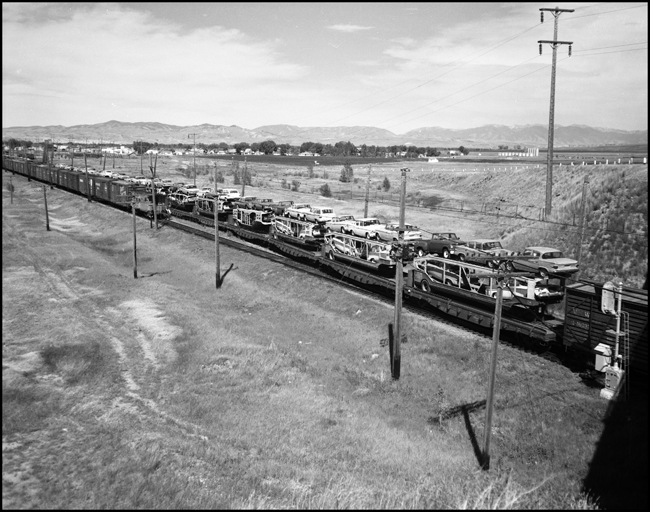MILW hotshot freights 263 and 264 pass at Three Forks, MT, with auto carriers on flat cars.