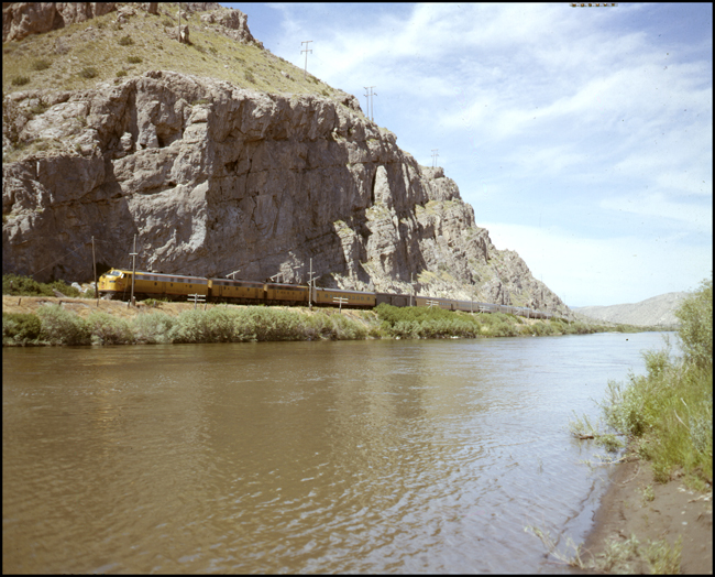 Color shot of MILW train 15, westbound Olympian Hiawatha, with three units, along Missouri River near Three Forks, MT.