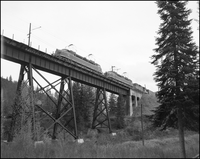 Milwaukee freight No. 263, with electric and diesel locomotive power, entering bridge east of Saltese, MT.