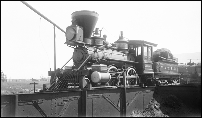 Virginia & Truckee 2-4-0 engine J.W. Bowker on flatcar in Bayshore Yard, San Francisco.