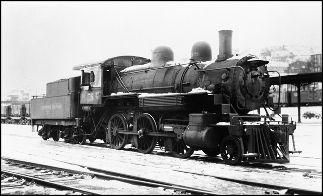Minus its headlight, derelict Copper Range 2-6-0 Mogul no. 58 sits in snow at Duluth Union Station.