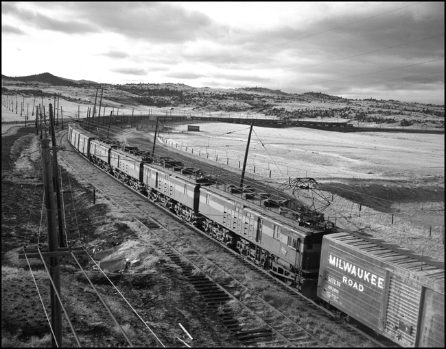 MILW helper E-49 electric locomotive helper cut into MILW train No. 264 with electric and Diesel power near Vendome, MT