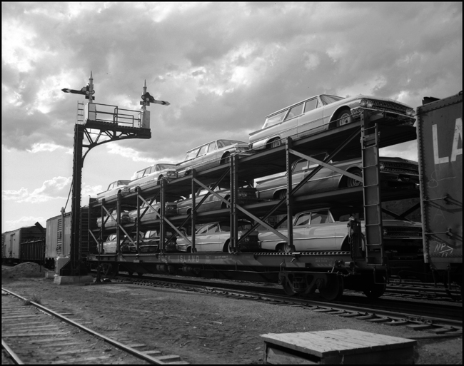 Automobile traffic by rail was rare in 1961.  But a new design, carrying new cars on three layer flatbeds rather than shoehorned into boxcars would soon recapture much new auto traffic.  Here si one of the first auto rack loads over the Northern Pacific