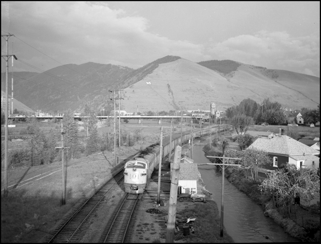 Station towers to the rear, train 16 leaves Missoula for the last time.  In less than 20 years the last freight train would pass over these tracks