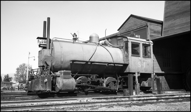 It's kind of a thermos bottle on wheels, a fireless steam locomotive that begins a work shift by getting a charge of steam from a stationary boiler.  Such engines were useful in places where a regular locomotive would be a fire hazard, like some chemical plants, and, in this case, a sawmill