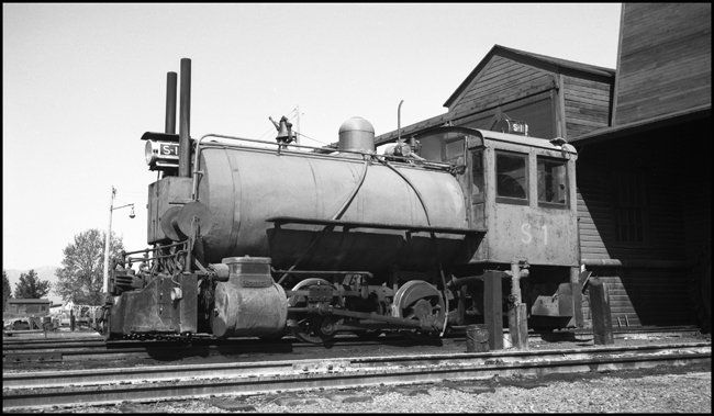 It's kind of a thermos bottle on wheels, a fireless steam locomotive that begins a work shift by getting a charge of steam from a stationary boiler.  Such engines were useful in places where a regular locomotive would be a fire hazard, like some chemical plants, and, in this case, a sawmill
