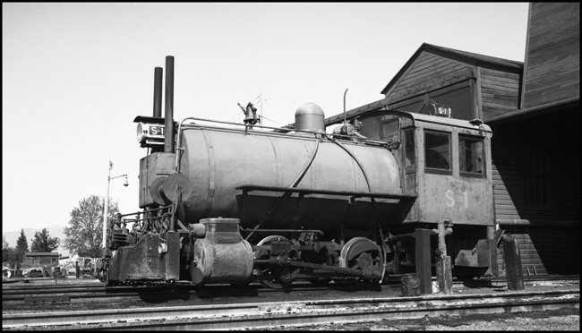 It's kind of a thermos bottle on wheels, a fireless steam locomotive that begins a work shift by getting a charge of steam from a stationary boiler.  Such engines were useful in places where a regular locomotive would be a fire hazard, like some chemical plants, and, in this case, a sawmill