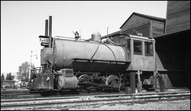 It's kind of a thermos bottle on wheels, a fireless steam locomotive that begins a work shift by getting a charge of steam from a stationary boiler.  Such engines were useful in places where a regular locomotive would be a fire hazard, like some chemical plants, and, in this case, a sawmill