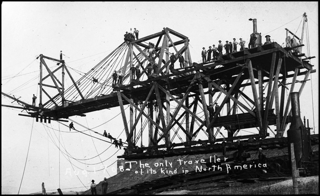 Most of the bridge building crew pose with their device, labeled as the only traveler of its kind in the US.  The scene is Tekoa WA. On the Milwaukee Road.