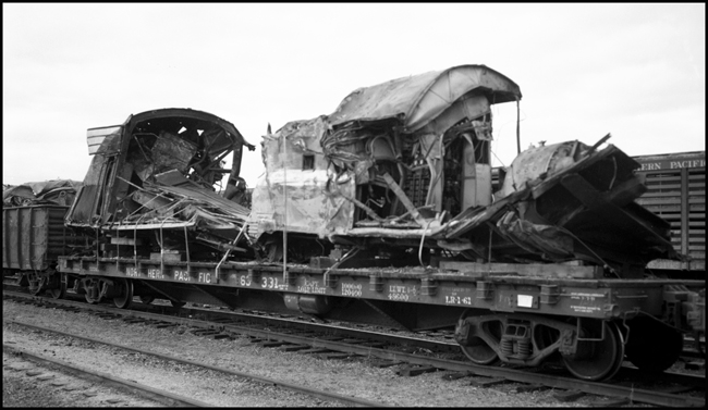 The remains of a diesel locomotive, removed by flatcar, after the wreck of the North Coast Limited at Granite Montana in 1962.