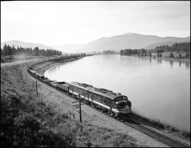 A west bound extra rail train along the Clark Fork River near Weeksville, MT.